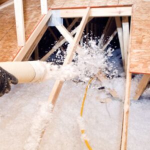 Blown in insulation being put into an attic.